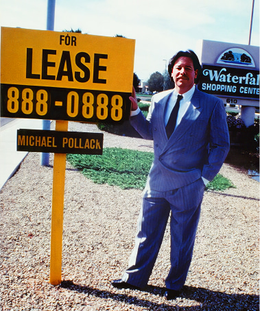 Michael Pollack standing next to a "For Lease" property sign